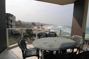 d'une table et de chaises sur un balcon avec vue sur la plage. dans l'établissement Seagull 405, à Margate