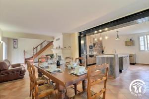 Villa Mariella في آرل: غرفة طعام ومطبخ مع طاولة وكراسي