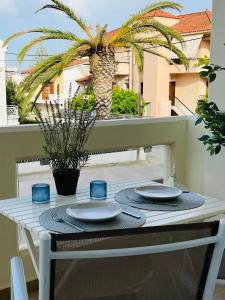 a table with plates and blue glasses on a balcony at Irida Apartment Nafplio in Nafplio