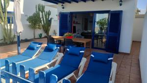 a patio with blue chairs and a table at Villa Lanzarote in Playa Blanca