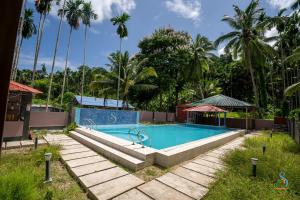 einen Pool in einem Resort mit Palmen in der Unterkunft Senses Havelock resort in Havelock Island