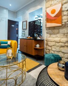 a living room with a yellow couch and a table at Hotel Lilas Blanc in Paris