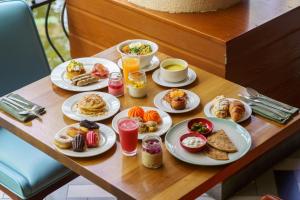 a table with plates of breakfast food on it at The Westin Resort Nusa Dua, Bali in Nusa Dua