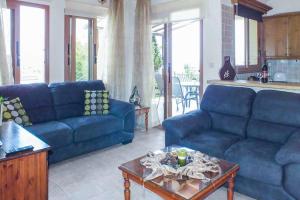 a living room with blue couches and a table at Villa Stella Argaka in Argaka