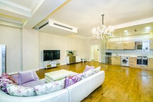 a living room with a white couch and a kitchen at Special VIP Mariott Apartment in Baku