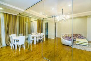 uma sala de estar com um sofá, uma mesa e cadeiras em Special VIP Mariott Apartment em Baku