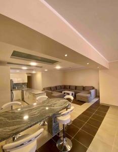 a living room with a counter and chairs and a kitchen at Apartment in el karma aqua beach resort hurghada near El gouna in Hurghada