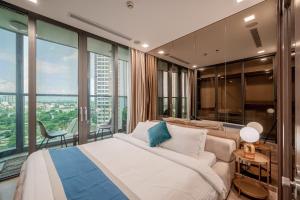 um quarto com uma cama, um sofá e janelas em Landmark 81 - Luxury 1,2,3,4 Bedroom Apartments - Stay in the Top of Vietnam em Ho Chi Minh