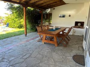 un tavolo e sedie di legno su un patio di BEACH HOUSE SEAFRONT VILLA LATOURA ORMOS PANAGIAS a Ormos Panagias
