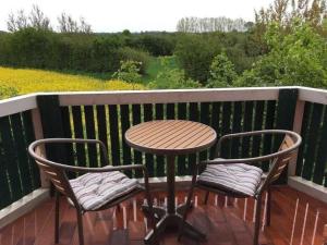 two chairs and a table on a balcony with a table and chairs at Ferienwohnung Mangelsen in Gelting +14 photos