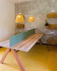 una mesa de madera en una habitación con dos luces colgantes en Samba Ahangama, en Ahangama