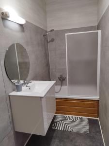 W białej łazience znajduje się umywalka i lustro. w obiekcie La Hasel w mieście Oberhaslach