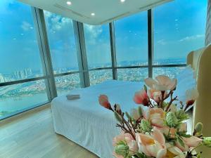 um quarto com uma cama e vista para a cidade em Landmark 81 - Luxury 1,2,3,4 Bedroom Apartments - Stay in the Top of Vietnam em Ho Chi Minh