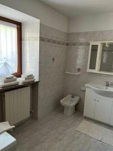 baño con lavabo y aseo y ventana en Casa Rina, en Gignod