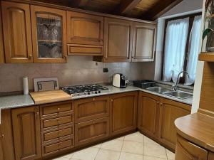 cocina con armarios de madera y horno con fogones en Casa Rina, en Gignod