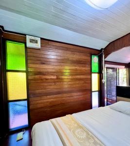 1 dormitorio con 2 camas y vidrieras en MrT Riverside Sampran มิสเตอร์ที โฮมสเตย์-ช้องนาง, en Sam Phran