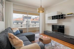 ein Wohnzimmer mit Sofa und Fernseher in der Unterkunft Ajuda IV by An Island Apart in Funchal