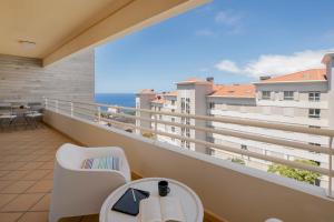 ein Balkon mit Tisch und Stühlen und Blick auf das Meer in der Unterkunft Ajuda IV by An Island Apart in Funchal