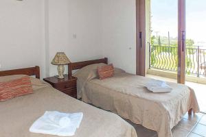 1 Schlafzimmer mit 2 Betten und einem Balkon in der Unterkunft Villa Agathi in Argaka