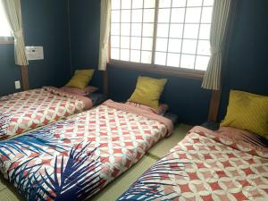 two beds sitting in a room with a window at Furinkyo・楓林居 5号館 in Osaka