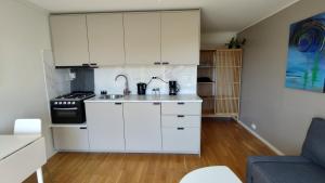 uma cozinha com armários brancos e um fogão em Kaldvell Apartman em Lillesand