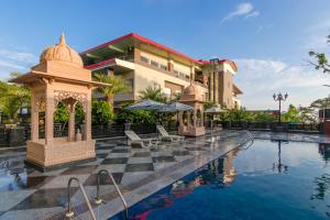 a hotel with a gazebo next to a swimming pool at Dhauladhar Heights Resort in Dharamshala