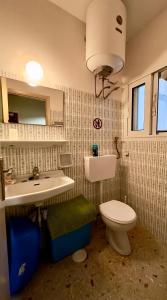 a bathroom with a white toilet and a sink at Loutraki Suites in Loutraki