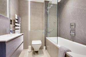 a bathroom with a toilet and a sink and a shower at Luxury 2 bed 2 bath Apartment in Canford Cliffs