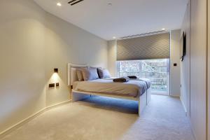 a white bedroom with a bed and a window at Luxury 2 bed 2 bath Apartment in Canford Cliffs