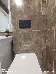 baño con aseo y pared de azulejos en Посуточно! Современная смарт-квартира м. Дворец спорта, Олимпийская., en Járkov