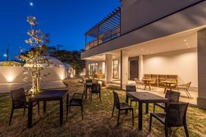 a house with tables and chairs in front of it at Innocence Resort -in Chiba Resol- in Hasunuma