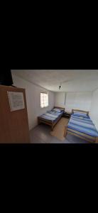 Duas camas num pequeno quarto com uma janela em Gostionica Kod Krlje em Nova Topola