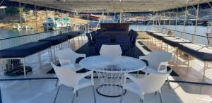 stół i krzesła na pokładzie łodzi w obiekcie Houseboat with aircon and splash pool - 2128 w mieście Kariba