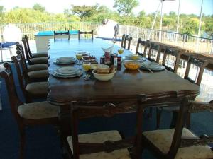 a wooden table with bowls of food on a deck at Houseboat with aircon and splash pool - 2128 in Kariba