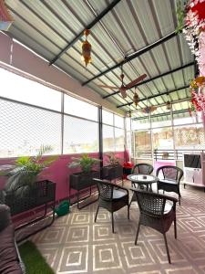 a patio with tables and chairs and windows at Beena Homestay in Jaipur