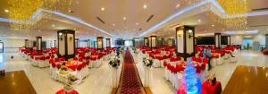 einen großen Bankettsaal mit roten und weißen Tischen und Stühlen in der Unterkunft Quê Tôi Hotel in Soc Trang