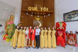 un grupo de personas posando para una foto frente a una tienda en Quê Tôi Hotel, en Soc Trang