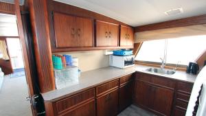 a small kitchen with wooden cabinets and a sink at Hotel Yacht Our Alissa in Barcelona