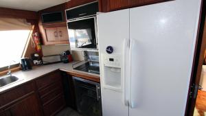 een keuken met een witte koelkast en een wastafel bij Hotel Yacht Our Alissa in Barcelona