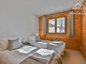 a bedroom with two beds and a window at Chalet Le Grand-Bornand, 5 pièces, 8 personnes - FR-1-391-158 in Le Grand-Bornand