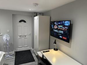 a room with a white door and a tv on the wall at Beautiful 1-Bed Modern Luxury Apartment in Luton in Luton
