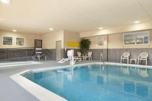 a swimming pool in a hotel with chairs and tables at Country Inn & Suites by Radisson, Georgetown, KY in Georgetown