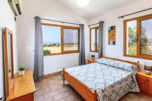 1 dormitorio con cama y ventana grande en Villa Veryina, en Peyia