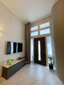 a living room with a tv and a large window at Civico29 appartamento bilocale in Como
