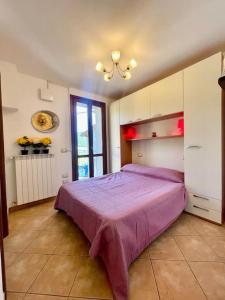 um quarto com uma cama roxa e uma janela em Residenze di Paola em Pavullo nel Frignano