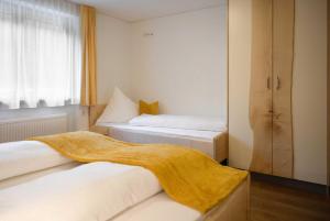 een slaapkamer met 2 bedden en een gele deken. bij Rosis Ferienwohnung in Vandans
