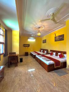 two beds in a room with yellow walls at Beena Homestay in Jaipur