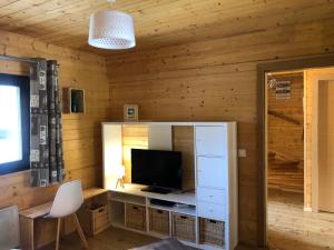 a living room with wooden walls and a television at Chalet Jad'Orres in Les Orres