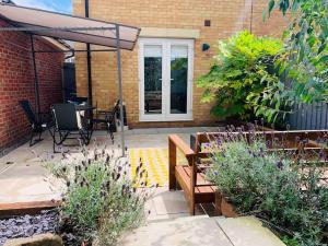 a patio with a table and chairs and an umbrella at Ty Lafant in Abergavenny