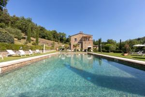 una gran piscina con una casa en el fondo en Podere la Casina Country Chic, en Rigomagno